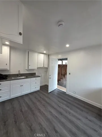 a large kitchen with wooden floor and stainless steel appliances