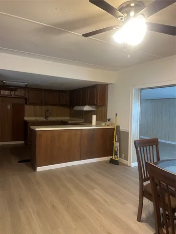 a kitchen with kitchen island a dining table chairs cabinets and stainless steel appliances