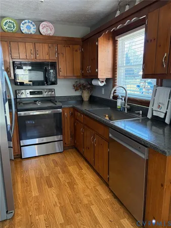 a kitchen with granite countertop a stove a sink and a microwave