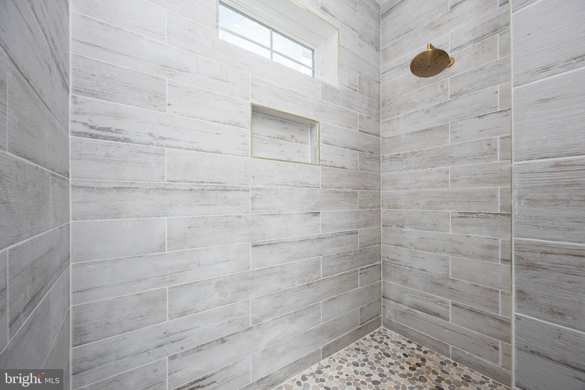 19438 Parsons Road Georgetown, DE 19947 - Photo 35 of 62 Sleek, modern shower with natural stone accents.