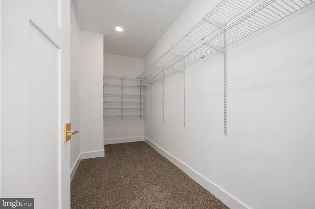 an empty room with fan and entrance