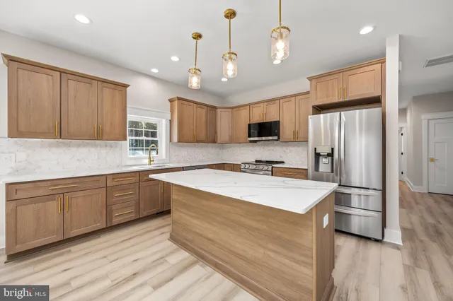 a large kitchen with kitchen island a sink stainless steel appliances and cabinets