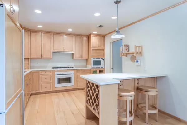 a kitchen with a table chairs stove a sink and dishwasher