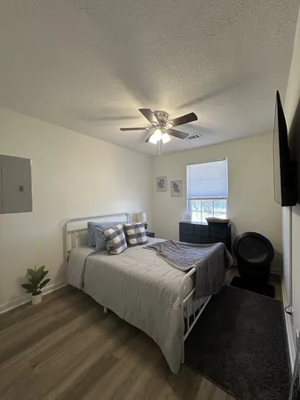 a bedroom with a bed and a flat screen tv