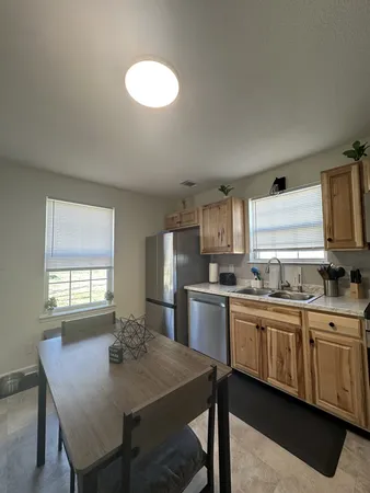a kitchen with a table chairs sink and cabinets