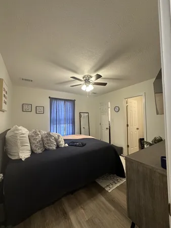 a bedroom with a bed and wooden floor