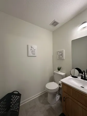 a bathroom with a toilet a sink and a mirror