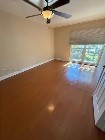 an empty room with a ceiling fan and window