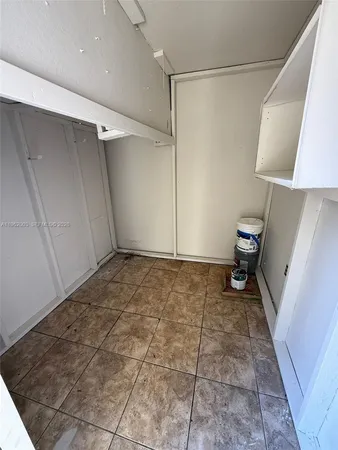a view of an empty room with wooden floor and a carpet