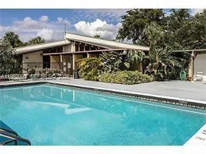 a house view with swimming pool and a yard
