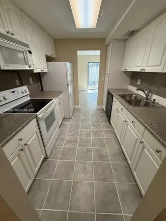a kitchen with a sink a stove and cabinets