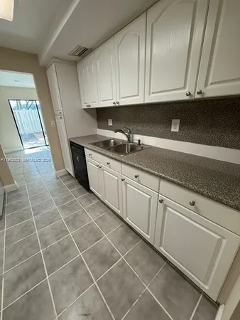 a kitchen with granite countertop a sink and cabinets