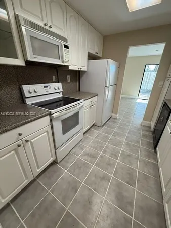 a kitchen with appliances cabinets and a sink