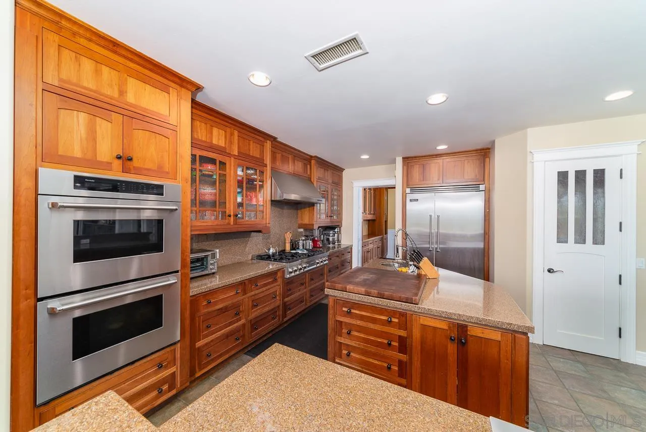 32070 Vía Vera Bonsall, CA 92003 - Photo 13 of 51 a kitchen with stainless steel appliances kitchen island granite countertop a stove a sink and a refrigerator