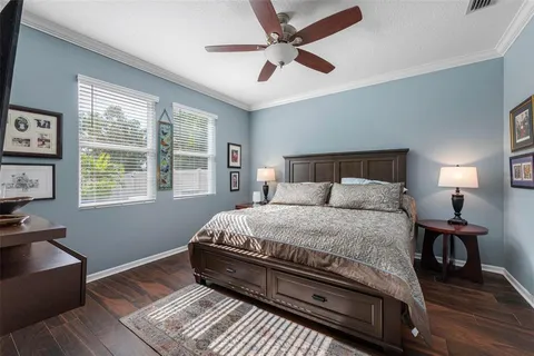 a bedroom with a large bed and a flat tv screen on dresser