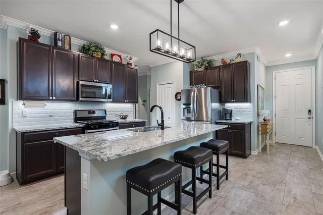 a kitchen with stainless steel appliances granite countertop a sink stove and refrigerator