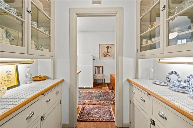 a view of a hallway view with wooden floor and rug