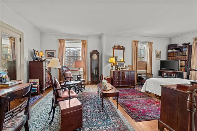 a kitchen with stainless steel appliances granite countertop a stove a sink dishwasher and white cabinets with wooden floor