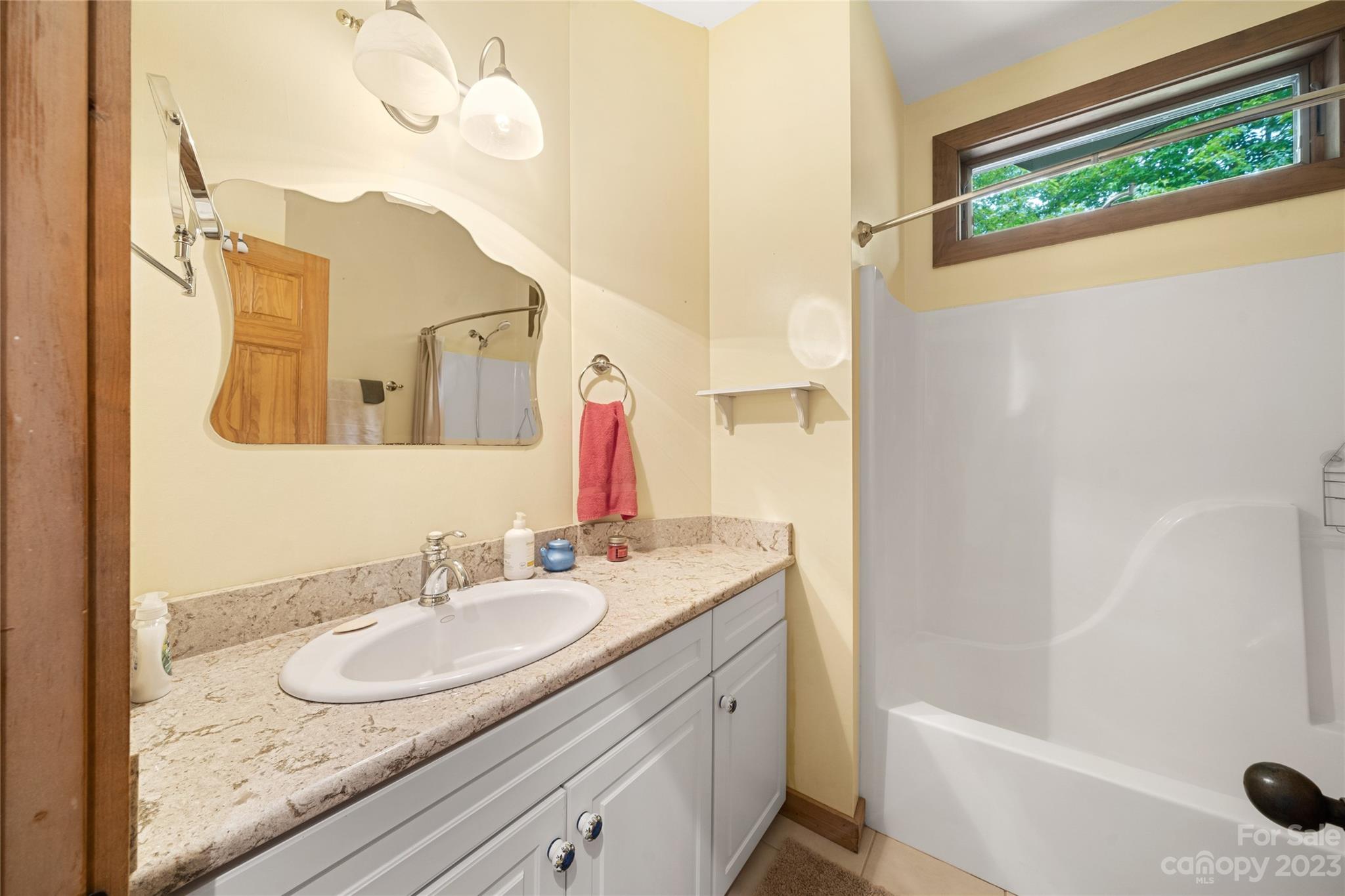193 Eagle Ridge Clyde, NC 28721 - Photo 24 of 48 a bathroom with a granite countertop sink and a mirror
