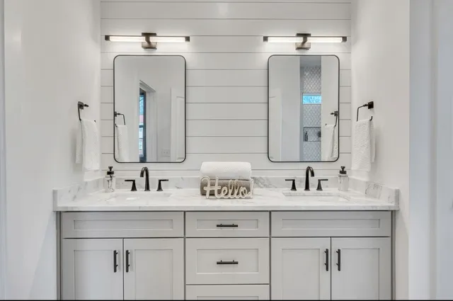 a spacious bathroom with double vanity and a mirror