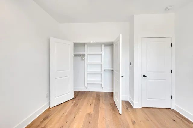 a view of empty room with wooden floor