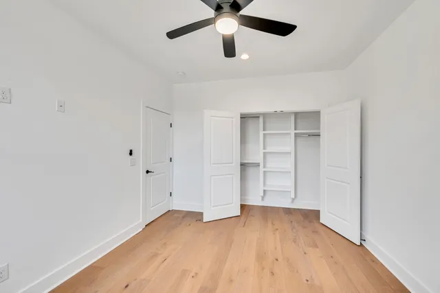 an empty room with a window and a ceiling fan