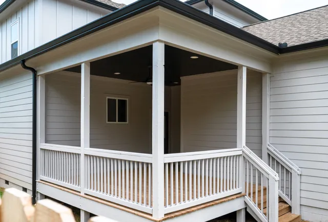 a view of a house with a small yard and wooden fence