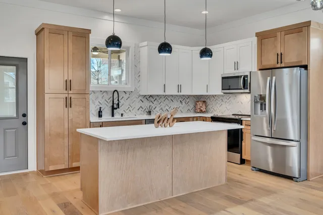 a kitchen with stainless steel appliances granite countertop a refrigerator a sink and a stove