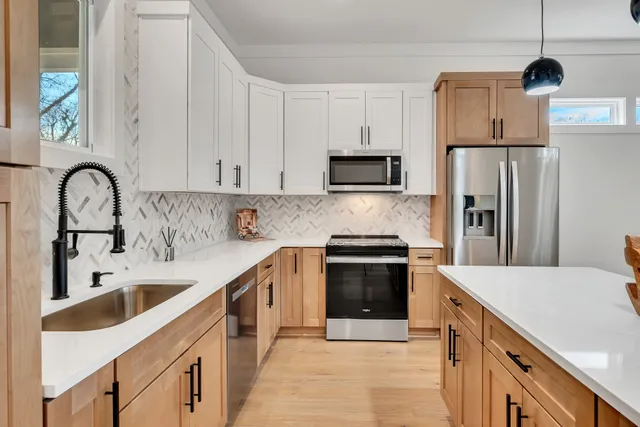 a kitchen with stainless steel appliances granite countertop a sink and a refrigerator
