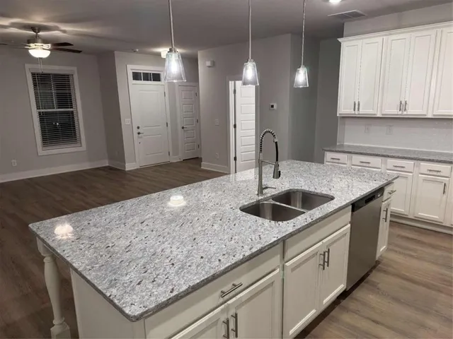 a kitchen with stainless steel appliances granite countertop a sink a stove and a wooden cabinets