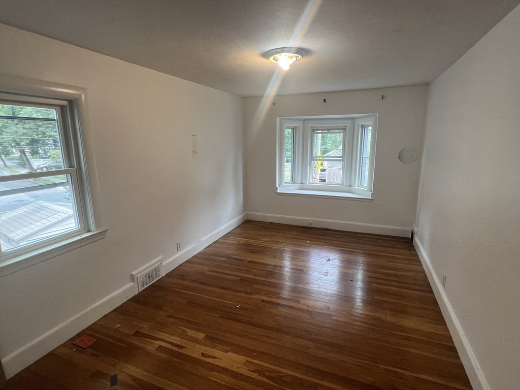 223 Woodcliff Road Newton, MA 02461 - Photo 8 of 15 a view of an empty room with wooden floor and a window