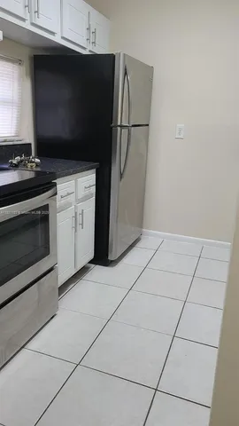 a kitchen with granite countertop a stove a microwave and a refrigerator