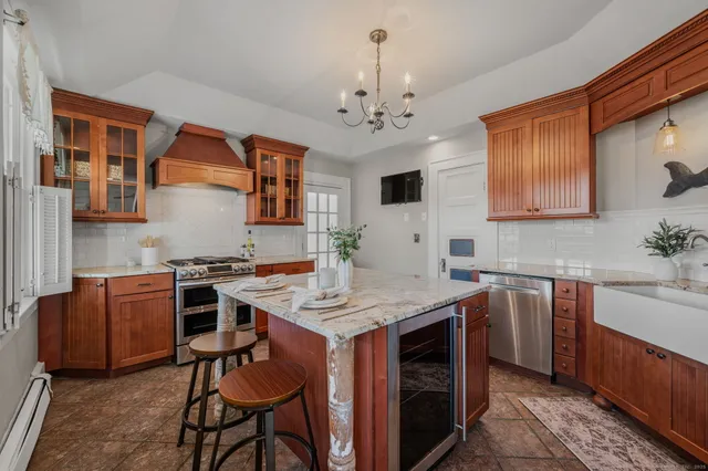 a kitchen with stainless steel appliances granite countertop a stove a sink dishwasher and a refrigerator with wooden cabinets