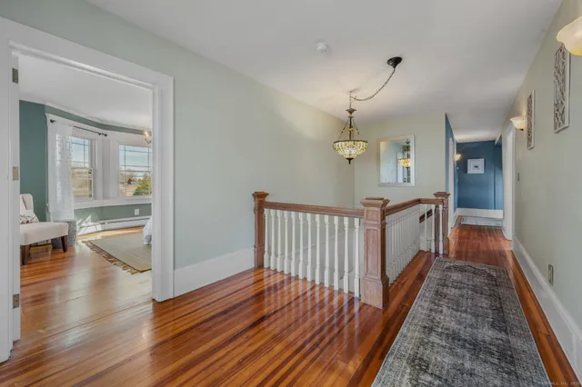 a view of a hallway view with wooden floor and staircase