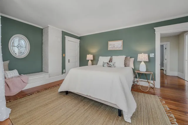 a bedroom with a bed and a table with wooden floor