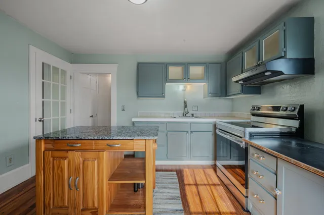 a kitchen with stainless steel appliances granite countertop a sink stove and cabinets