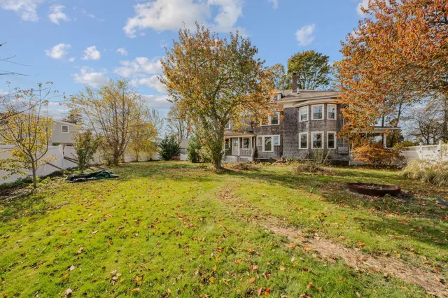 a view of residential houses with yard and trees
