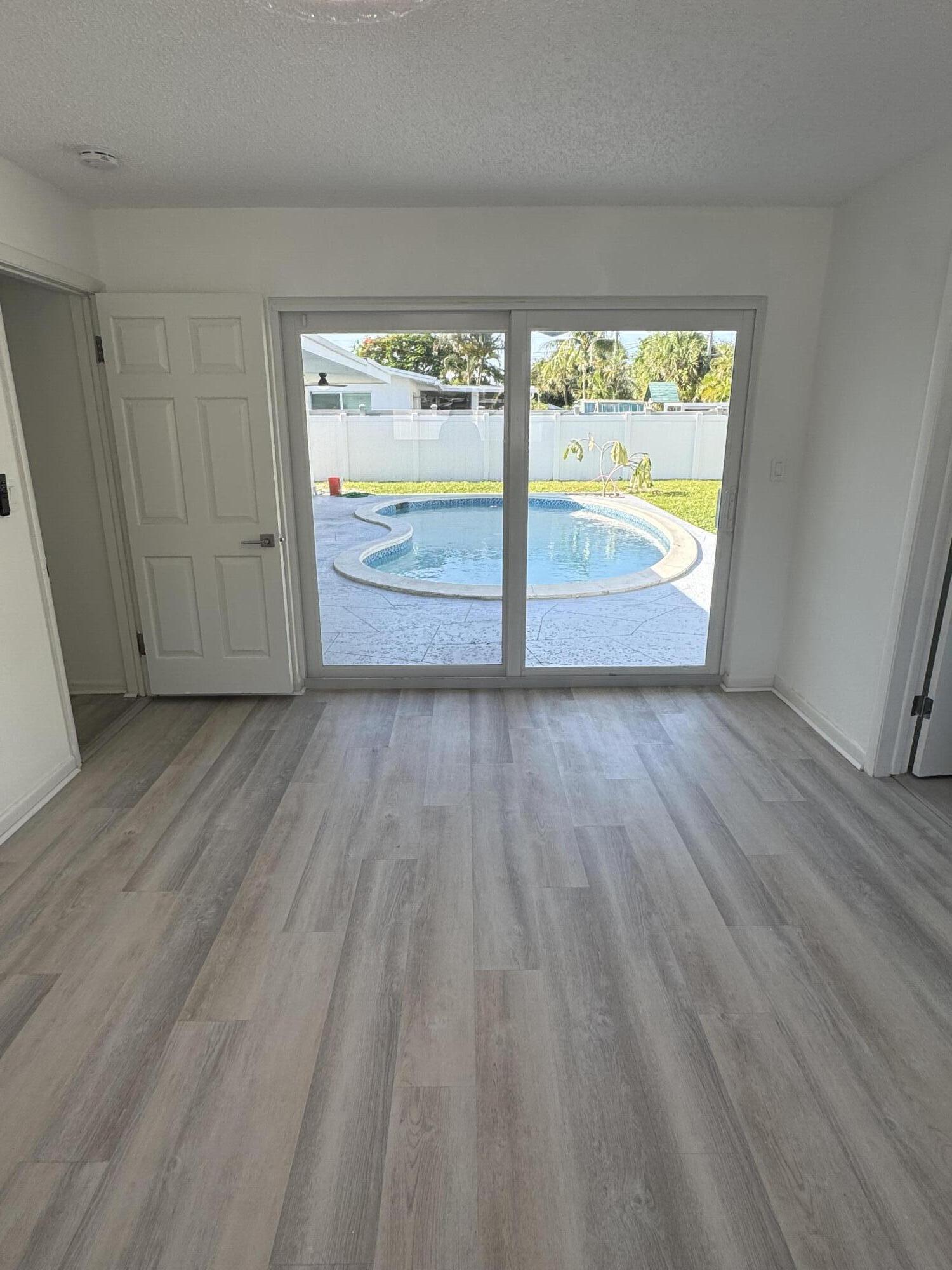 28 Southwest 9th Avenue Boca Raton, FL 33486 - Photo 4 of 16 a view of an empty room with a window and wooden floor