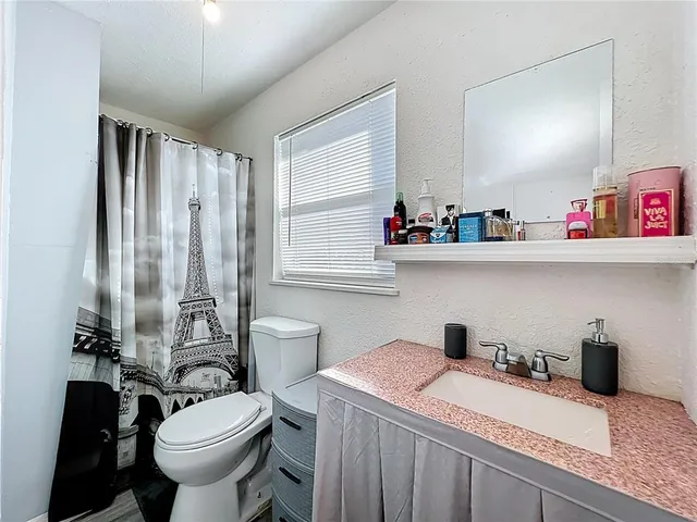 a bathroom with a sink a toilet and a shower