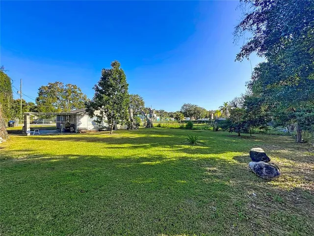 an aerial view of residential houses with outdoor space and trees