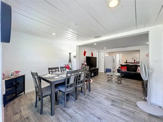 a living room with furniture a wooden floor and a flat screen tv