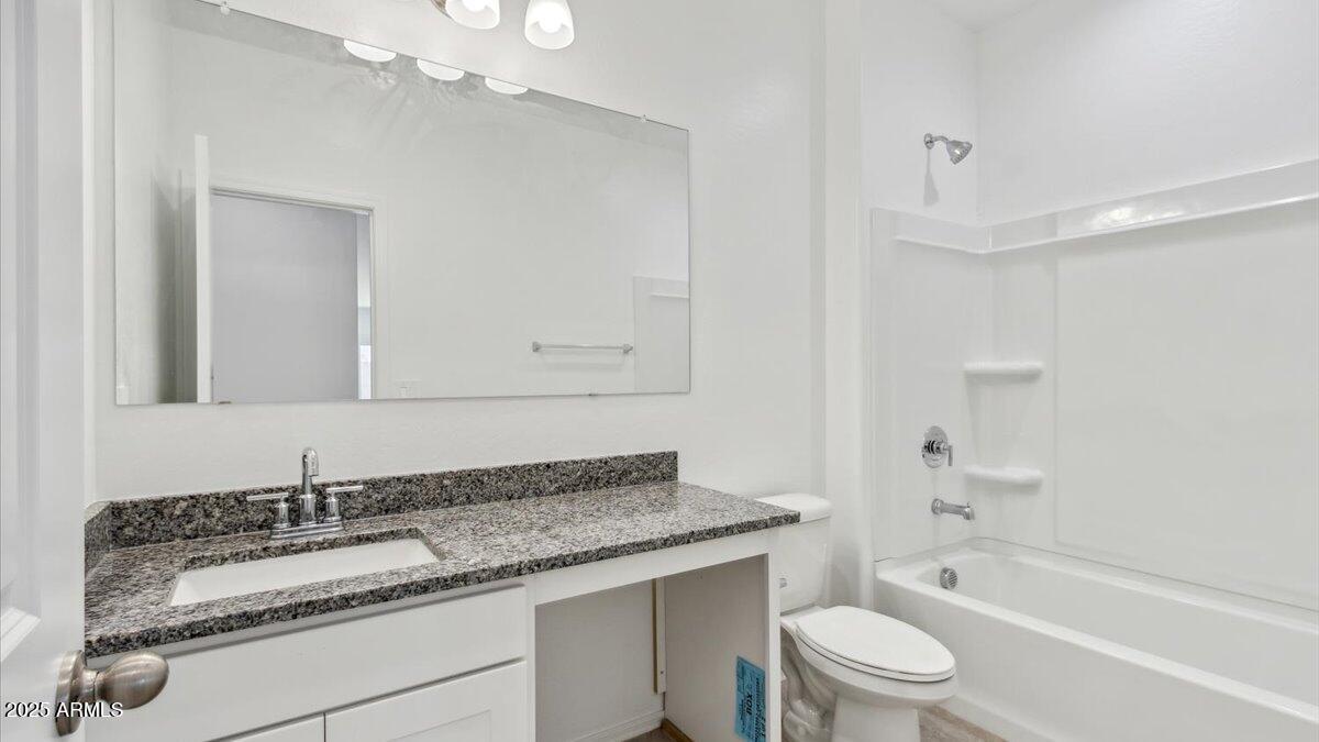 2032 Starkey Avenue Apache Junction, AZ 85120 - Photo 2 of 16 a bathroom with a granite countertop sink a toilet and bathtub