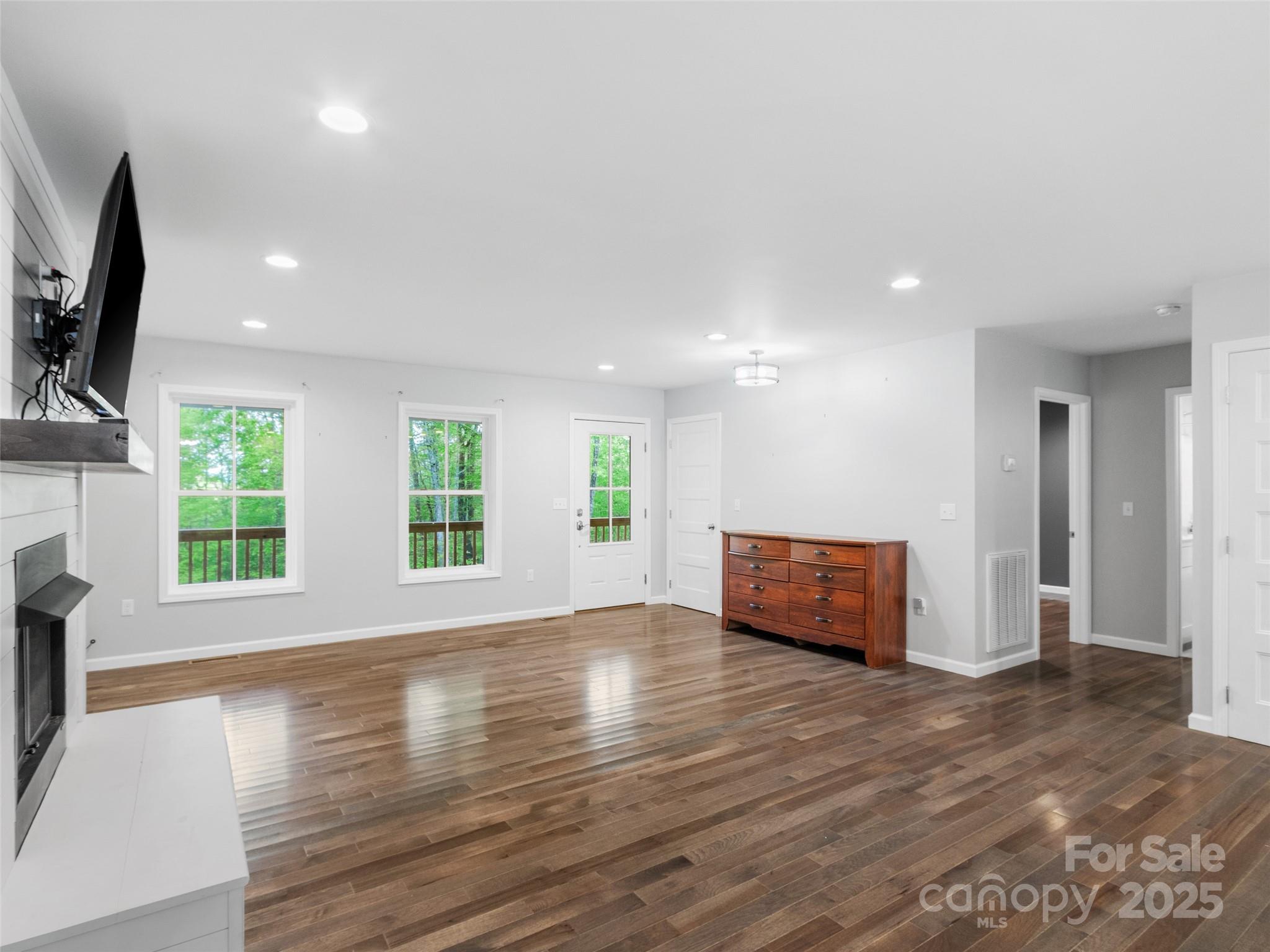 155 Pebble Ridge Road Spruce Pine, NC 28777 - Photo 8 of 39 an empty room with wooden floor and windows