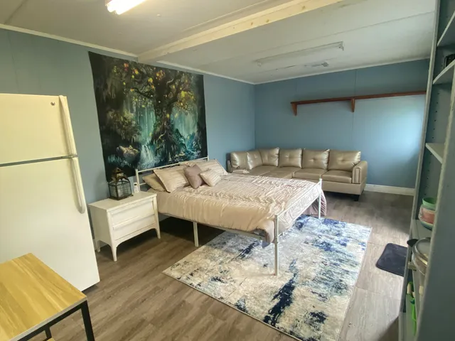 a bedroom with a bed and a flat tv screen on the dresser