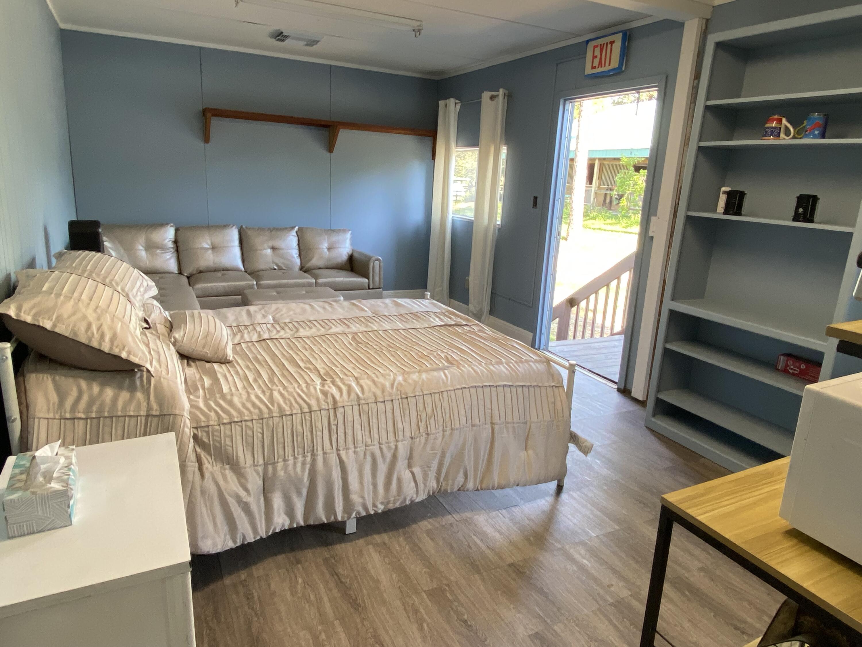 2141 B Road, Unit STUDIO 3 Loxahatchee Groves, FL 33470 - Photo 4 of 45 a bedroom with a bed and a flat tv screen on the dresser