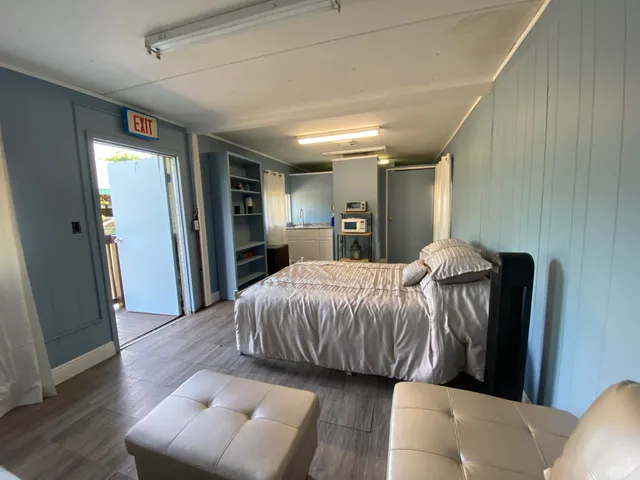 a living room with furniture and a walk in closet with wooden floor