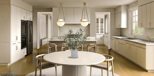 a kitchen with stainless steel appliances granite countertop a table chairs and a refrigerator