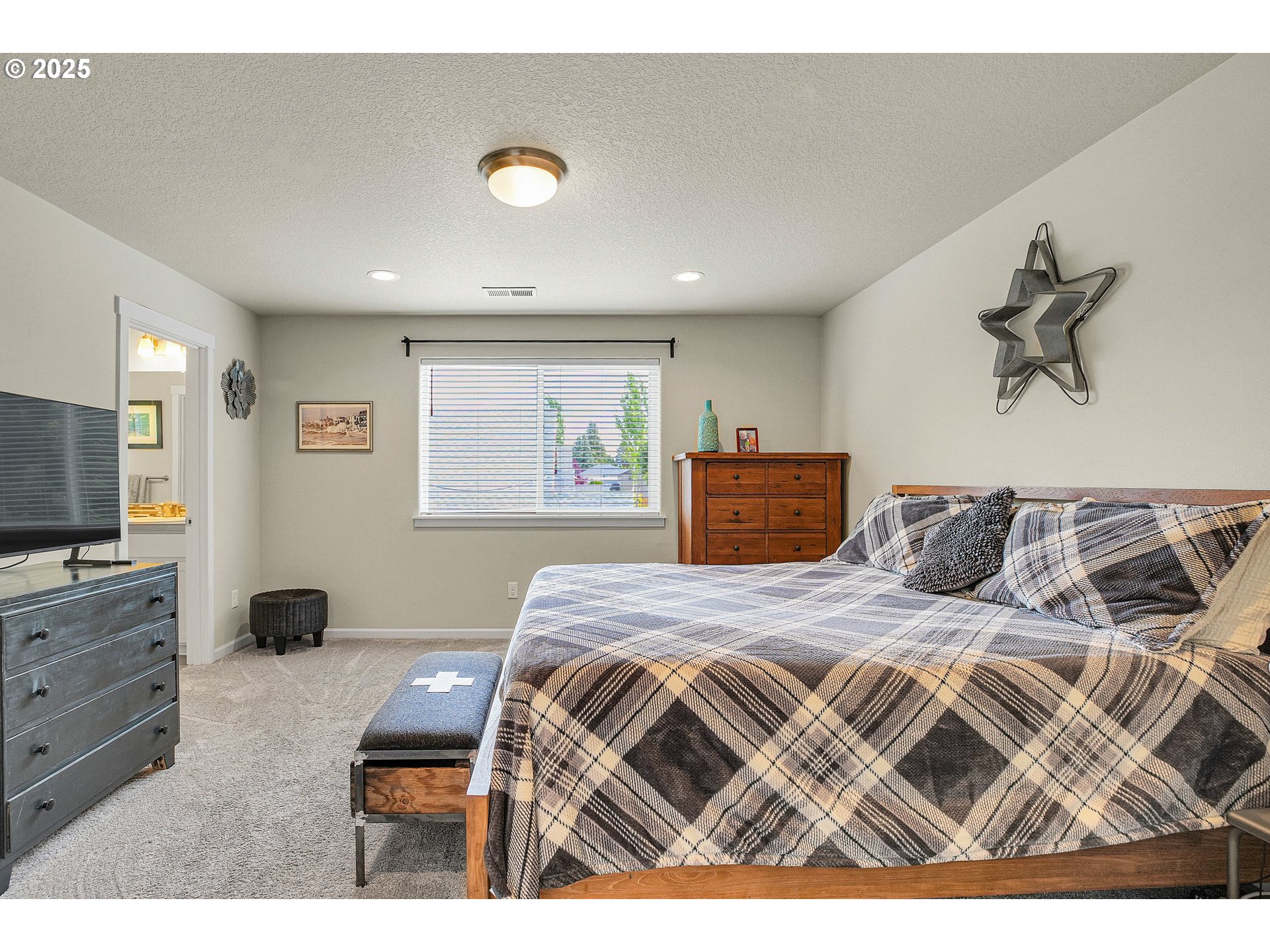 2796 Southeast Baker Avenue Gresham, OR 97080 - Photo 18 of 48 a bedroom with a large bed and a flat tv screen on dresser
