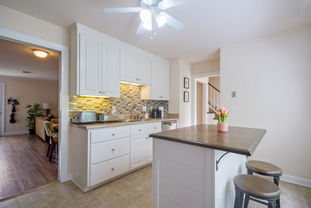 1030 General George Patton Road Nashville, TN 37221 - Photo 10 of 31 a kitchen with white cabinets and chandelier