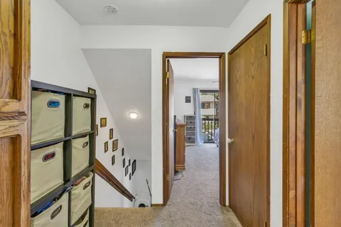 a view of a hallway with wooden floor and staircase